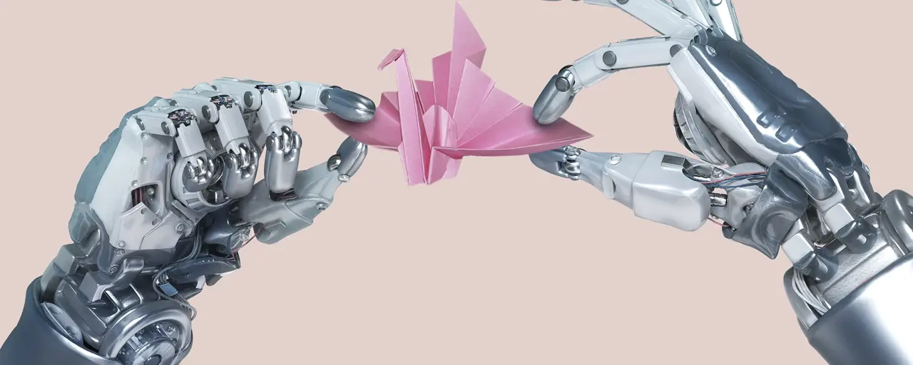 Two robot arms hold up a pink origami swan