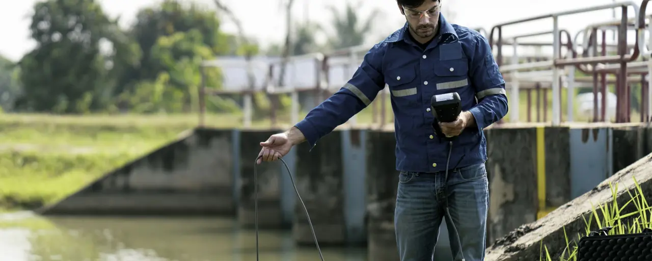 A technician use the Professional Water Testing equipment to measure the water quality at the public canal, Portable multi parameter water quality measurement , water quality monitoring concept.