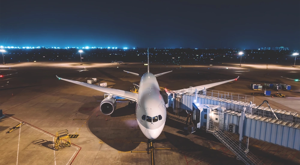 An aeroplane on a tarmac at night