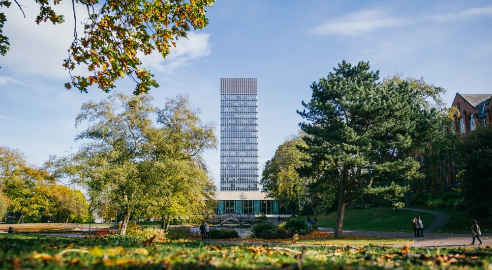 University campus with trees and a tall modern building in background