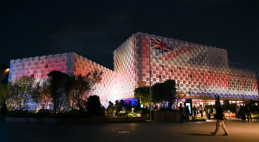 UK Pavilion at night, Expo 2025 Osaka, illuminated with UK flag lights.
