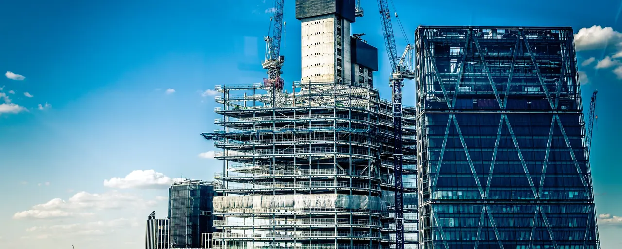 Tall building with scaffolding in London with blue skyline