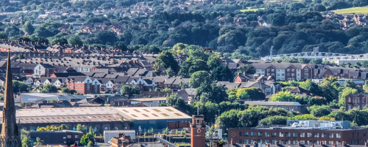 View of Darwen town centre, with buildings in the foreground and trees in the background