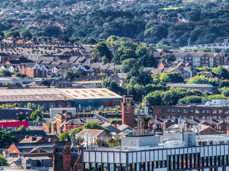 View of Darwen town centre, with buildings in the foreground and trees in the background