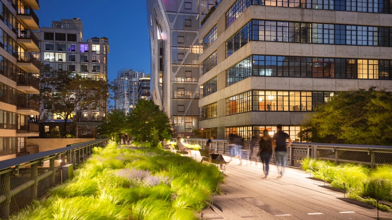View of buildings late in the evening with pedestrians walking through city