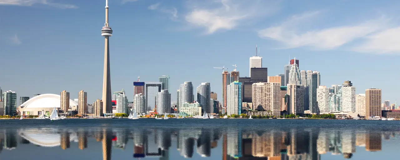 View of Canada's skyscrapers and Toronto Tower with the reflection bouncing off the sea.