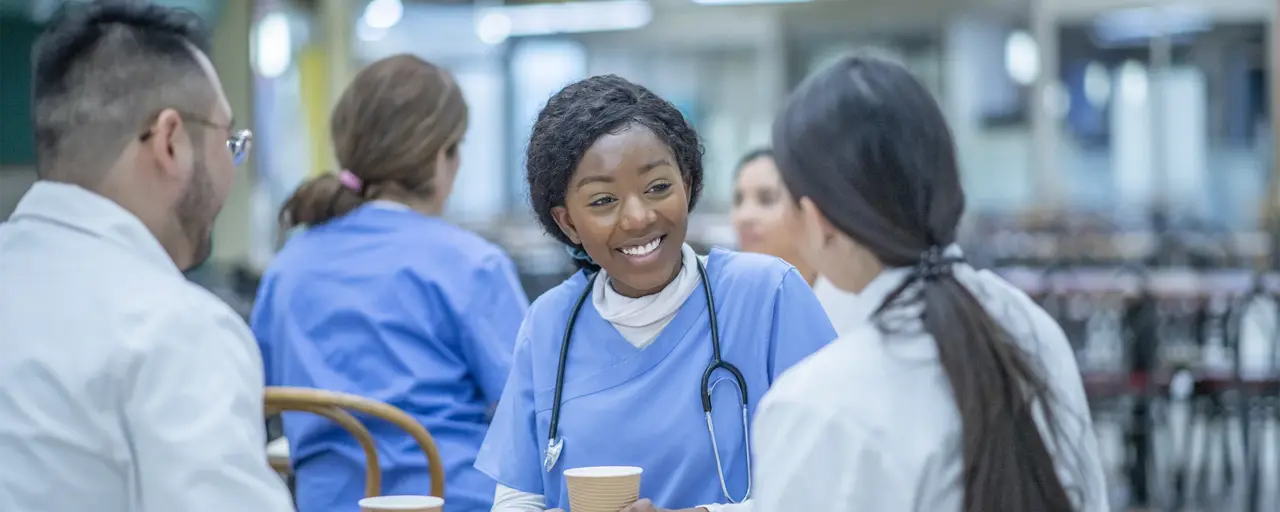 Medical professionals sitting at a table drinking hot beverages