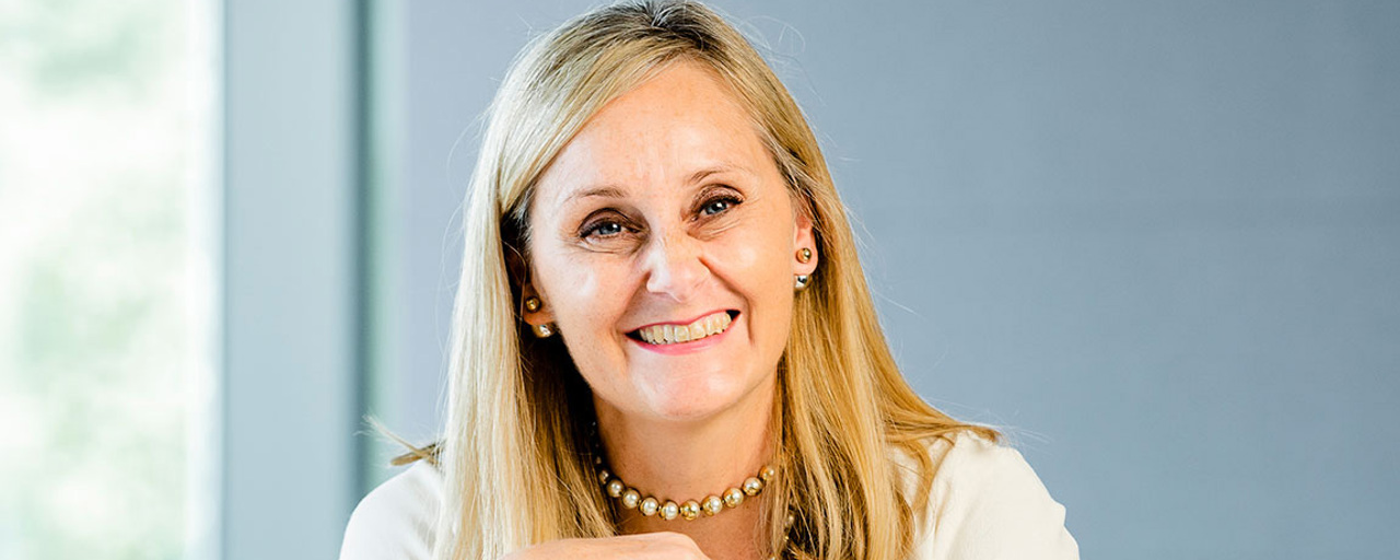 Director and Global Head of Risk Management, Judy Adams, smiling at a desk