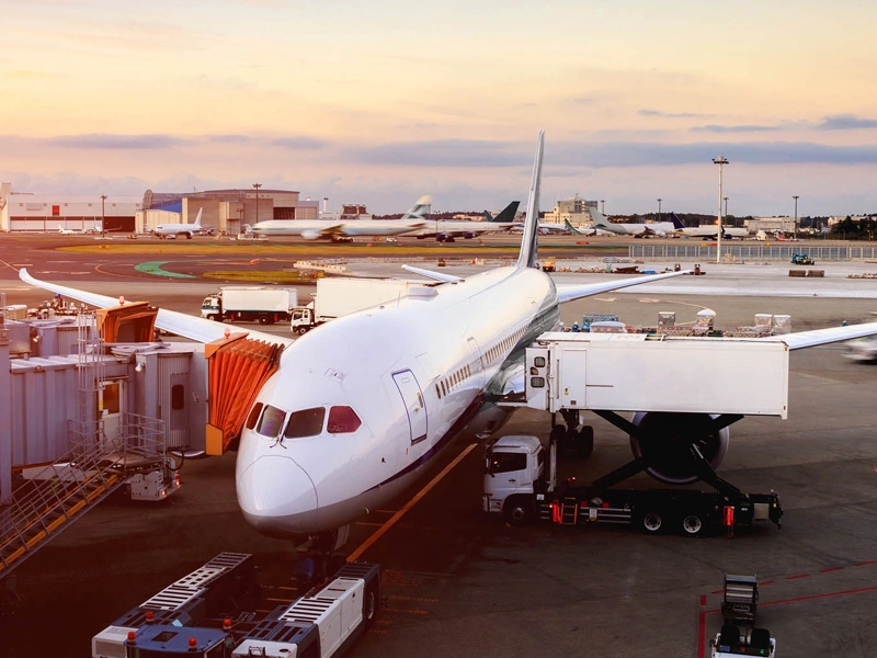 Plane and service vehicles on tarmac, Heathrow Airport, UK