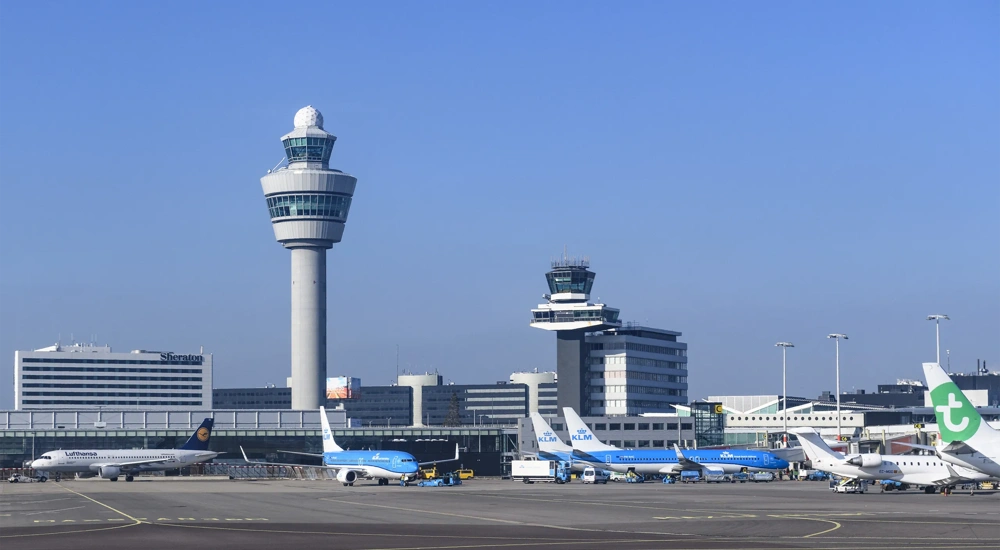 Airplanes at Amsterdam Schiphol Airport in The Netherlands during a springtime sunset.