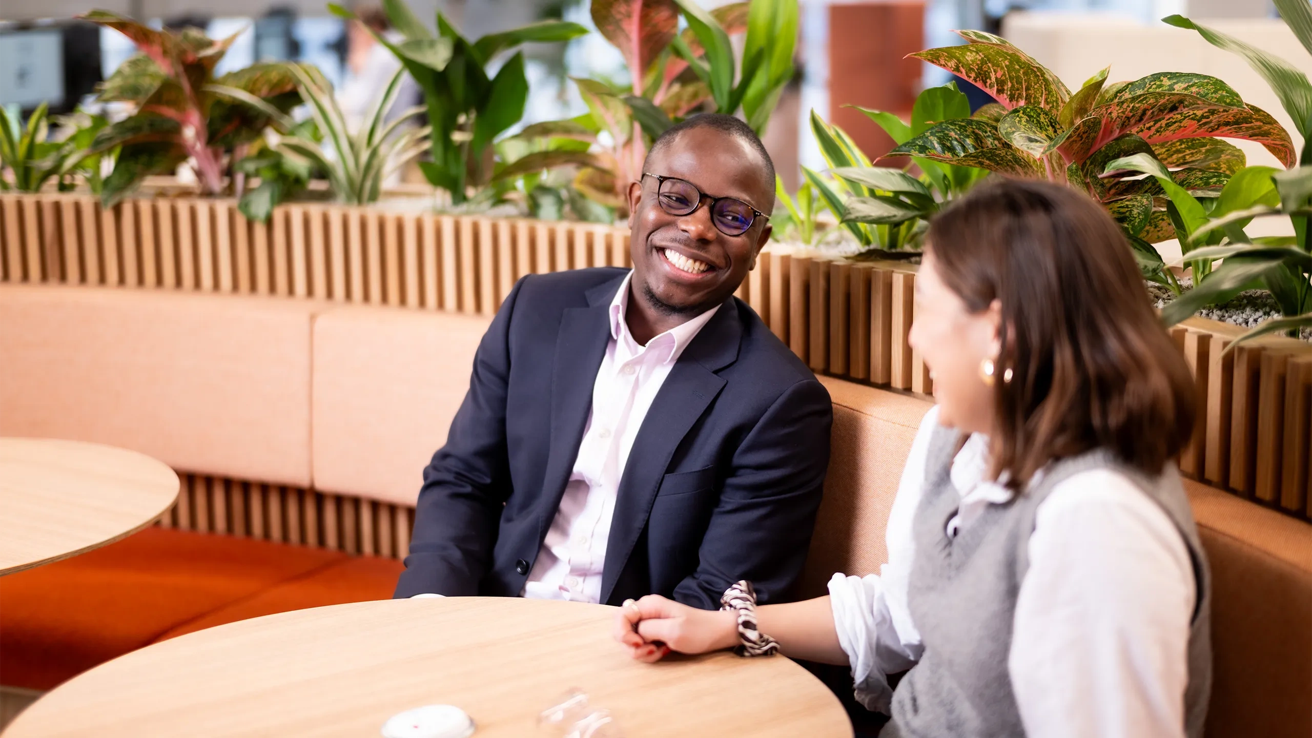 Male and female colleagues having a casual chat in the break room.
