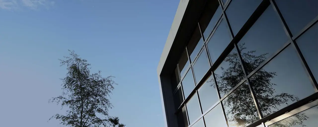 View of an office with the tree reflecting on the glass of the building