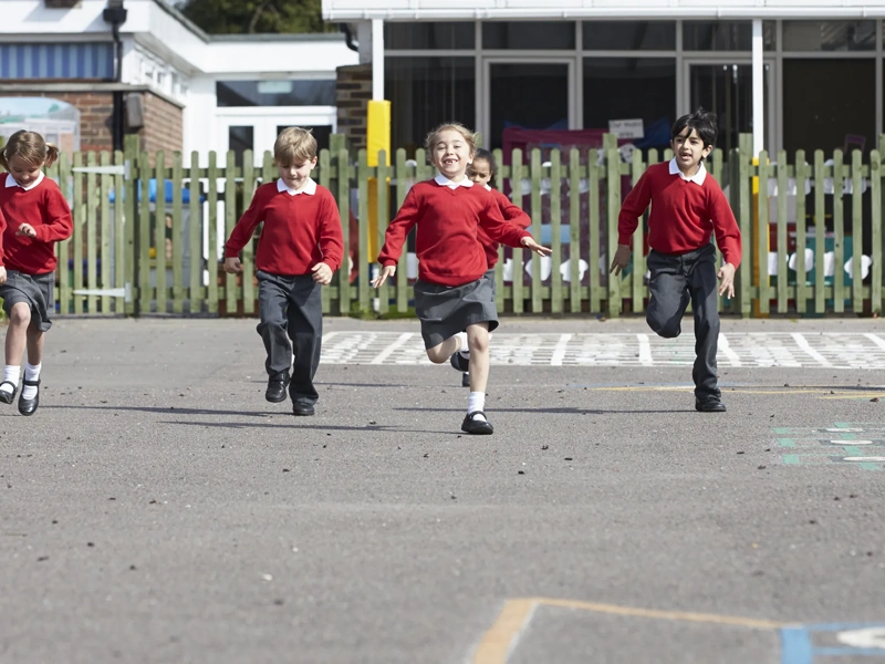 Primary School Pupils Running In Playground Towards Camera