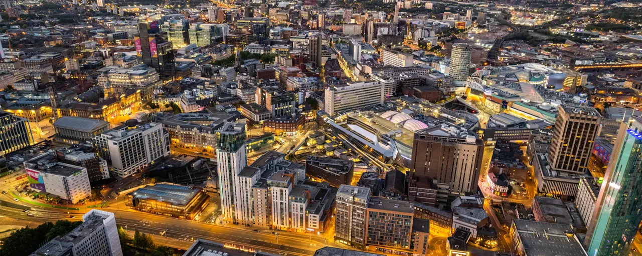 View of a city centre with high-rise buildings lit up at night