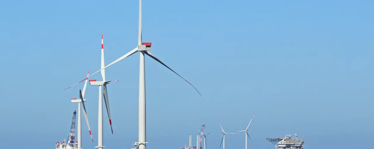 Multiple offshore wine turbines; daytime