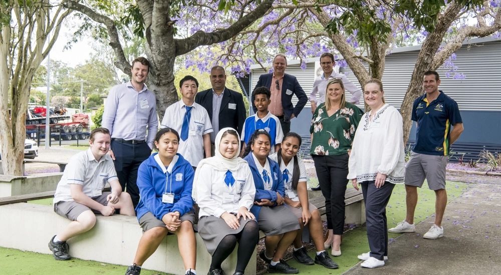 Group of school children and teachers surrounded by trees