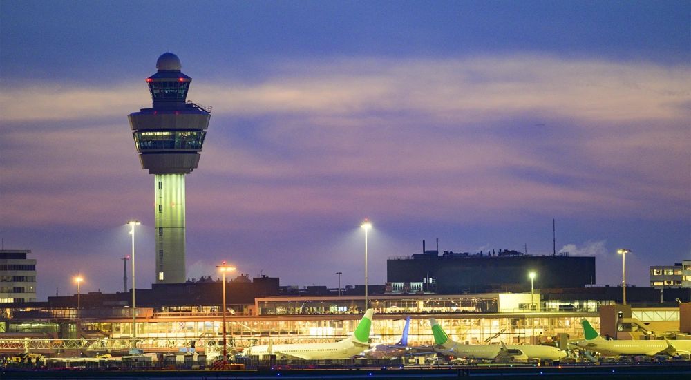 Schiphol airport with various airplanes at night. Schiphol is one of the busiest and largest airports in Europe, located near Amsterdam, Netherlands. It serves as a major hub for international flights and is a key gateway to Europe.