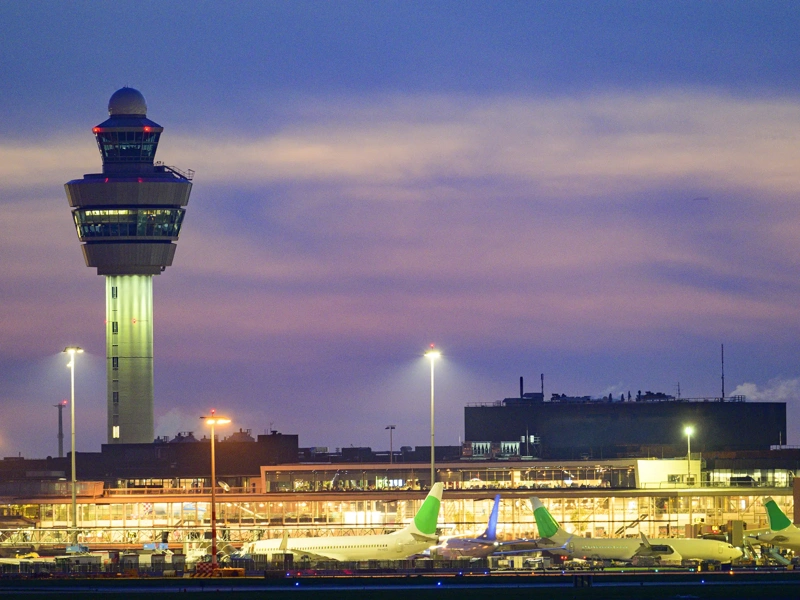 Schipol Airport airfield, terminal and air traffic control tower illuminated at dusk, Amsterdam, The Netherlands