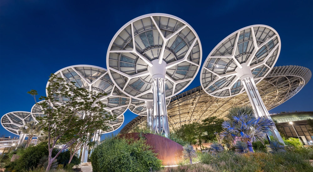 Multiple mushroom shaped solar panels against dark blue sky
