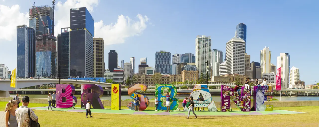 People enjoying colorful Brisbane sign at South Bank, Queensland, Australia.