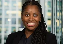 Portrait of Charlene Singh, Global Business Generation Lead, Infrastructure, with city landscape featuring building with lots of windows in the background.