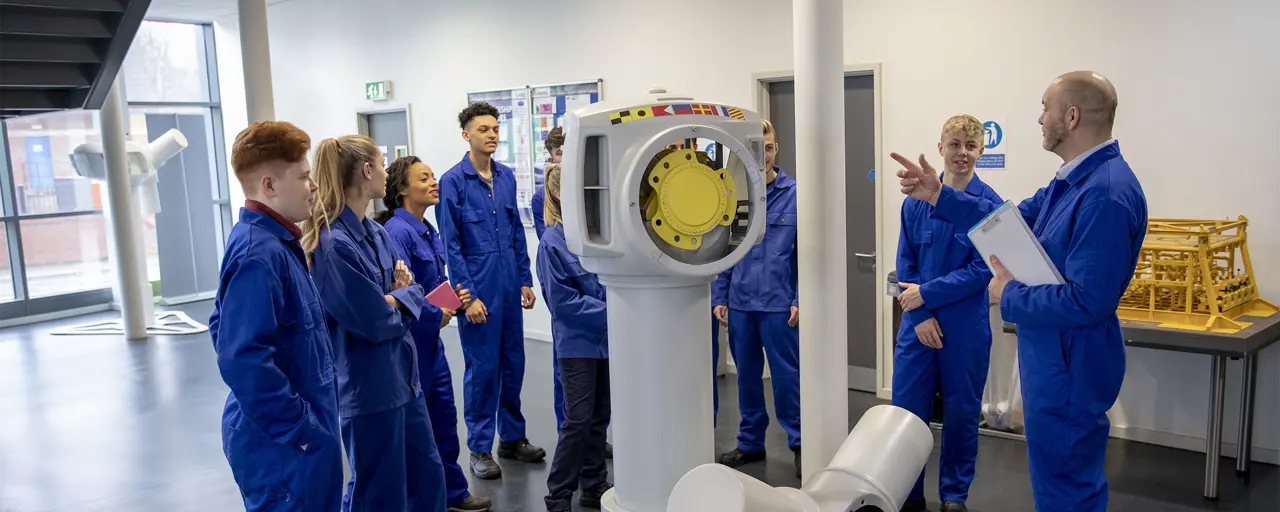 Group of people in blue suits standing by machines