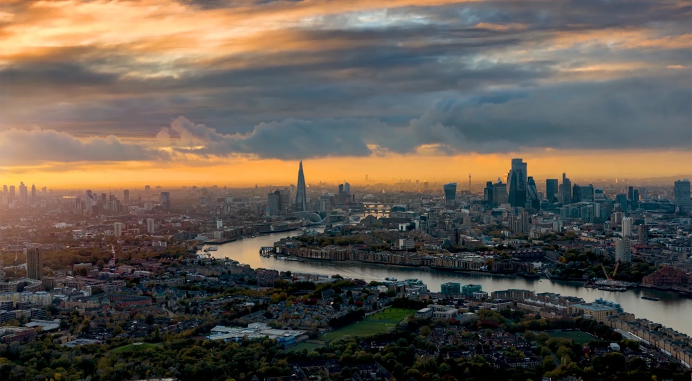 High panoramic view of the urban skyline of London, England, with the river Thames leading into the City disctrict and beyond during a beautiful sunset