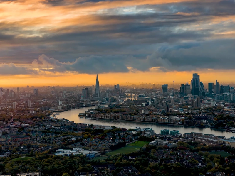High panoramic view of the urban skyline of London, England, with the river Thames leading into the City disctrict and beyond during a beautiful sunset