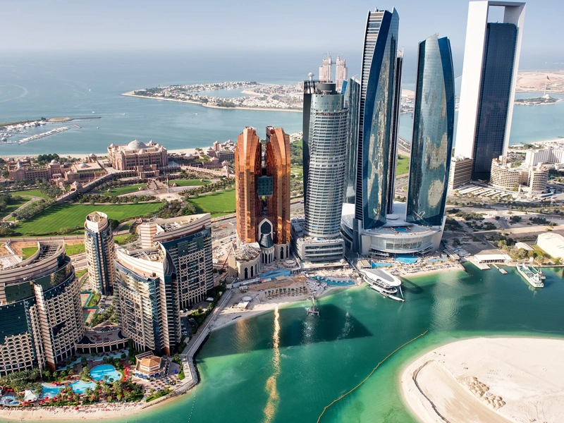 Part of Abu Dhabi, UAE with tall buildings and surrounding area viewed from the helicopter. Many details are visible in the image.