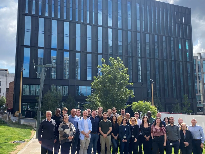 Turner and Townsend Sheffield colleagues standing outside new black window orientated office.