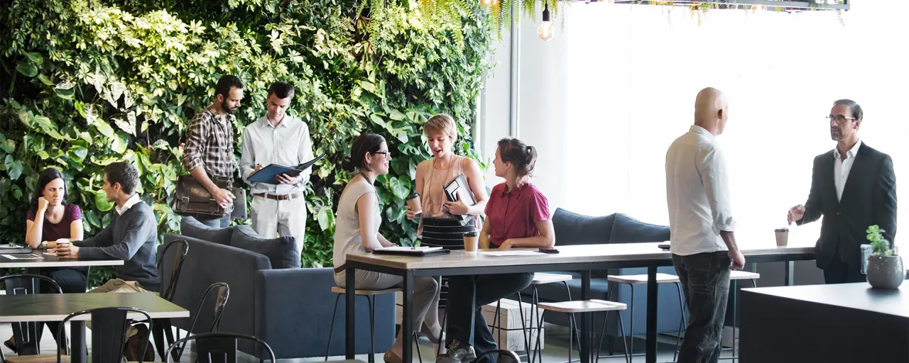 People in group standing in front of living wall