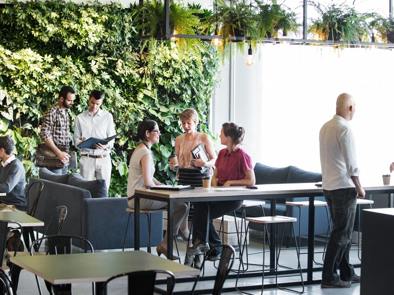 People in group standing in front of living wall