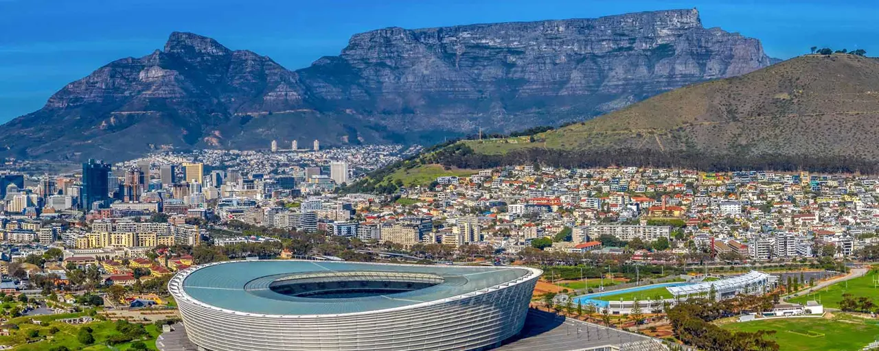 Skyline photo of Cape Town with Cape Town Stadium in the foreground and the City Bowl/Central Business District and Table Mountain in the background