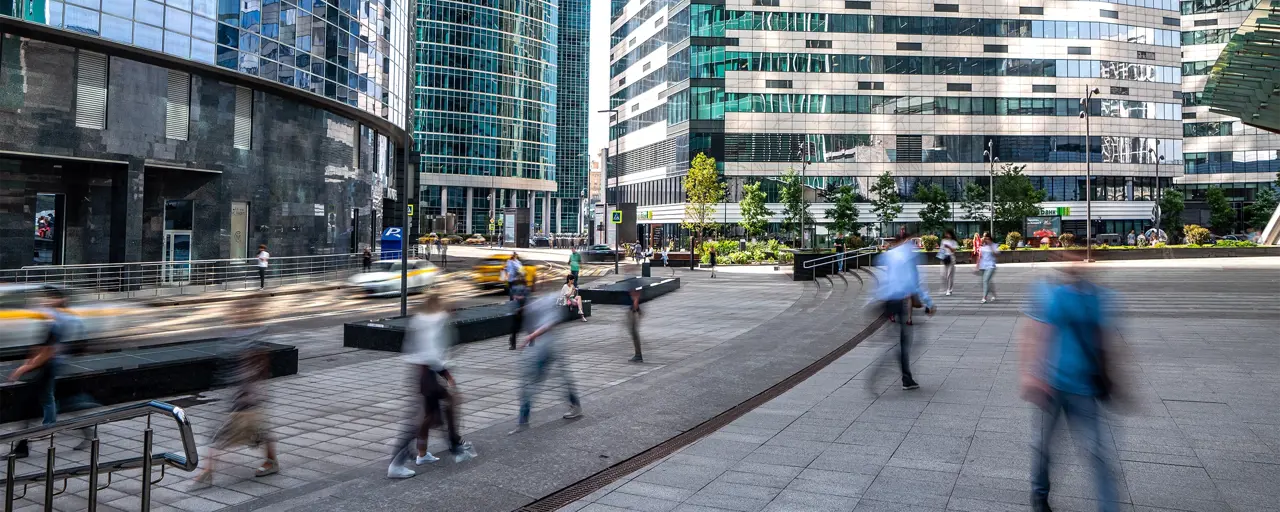 Pedestrians walking surrounded by high rise glass office buildings