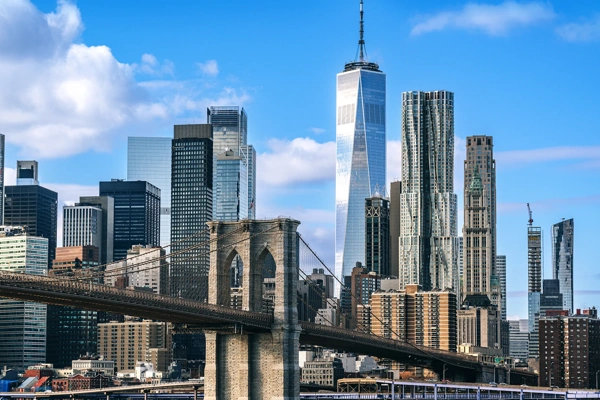 Iconic view featuring the Brooklyn Bridge against the modern New York City skyline on a clear day, showcasing the city's architectural beauty and urban energy.