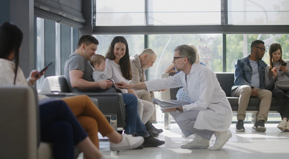 Doctor speaking to couple with baby in hospital