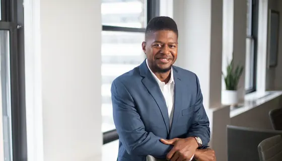 Wayne Lambert, Director of Supplier Diversity, US, in an office with white walls and beige chairs and a pot plant