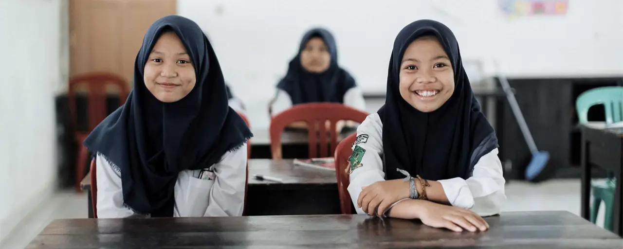 Two young females smiling in classroom