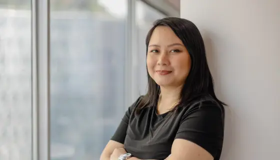 Portrait of Siti Norman, Director, Digital, Singapore, standing against white background and window.