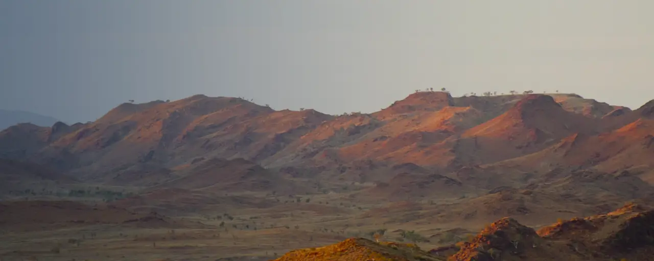 Brown mountains against blue / grey sky