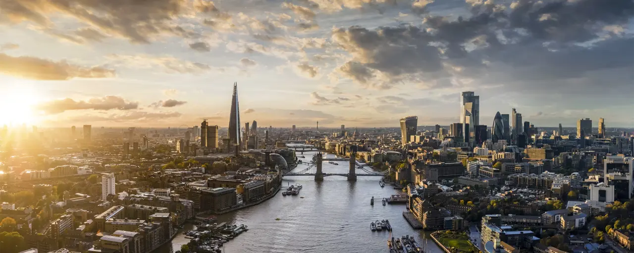 View of London landmarks such as the London bridge and River Thames with the sun beaming down on the view of London 