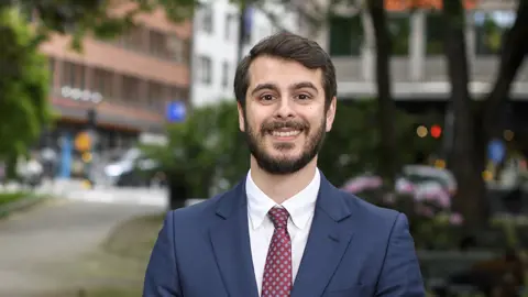 Portrait of Nima Aase, Managing Director, Scandinavia, outside in front street with trees and tall buildings,