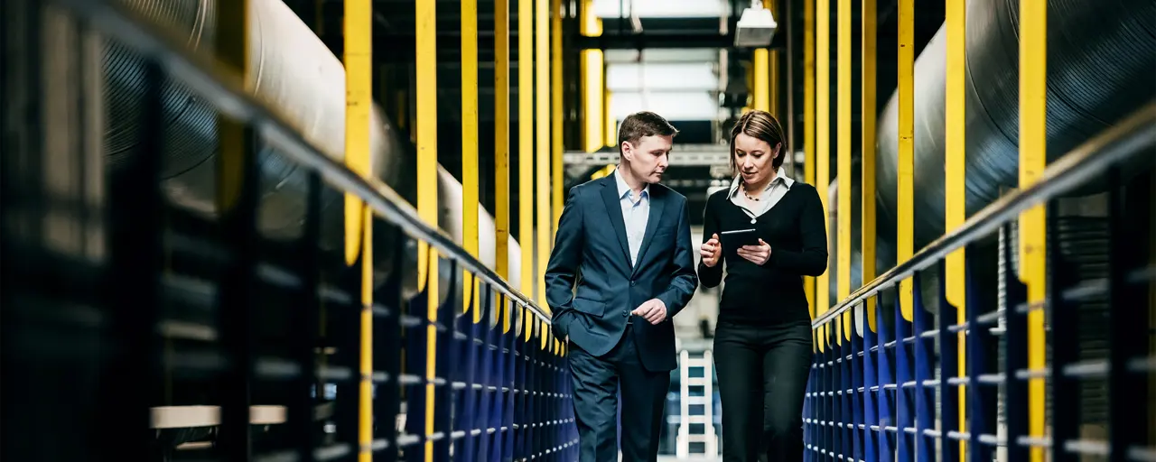 Two professionals walking through a factory