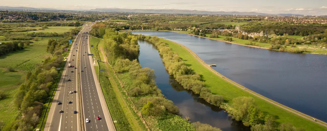 Motorway alongside greenery and water