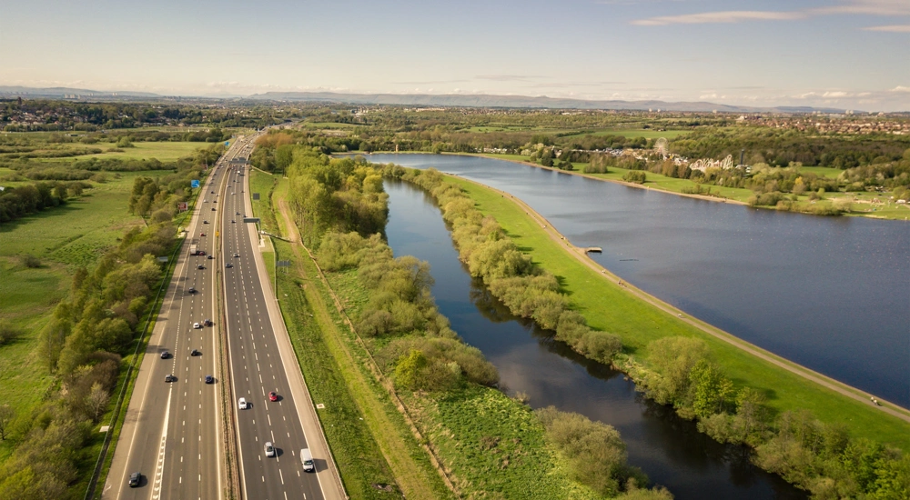 Motorway alongside greenery and water