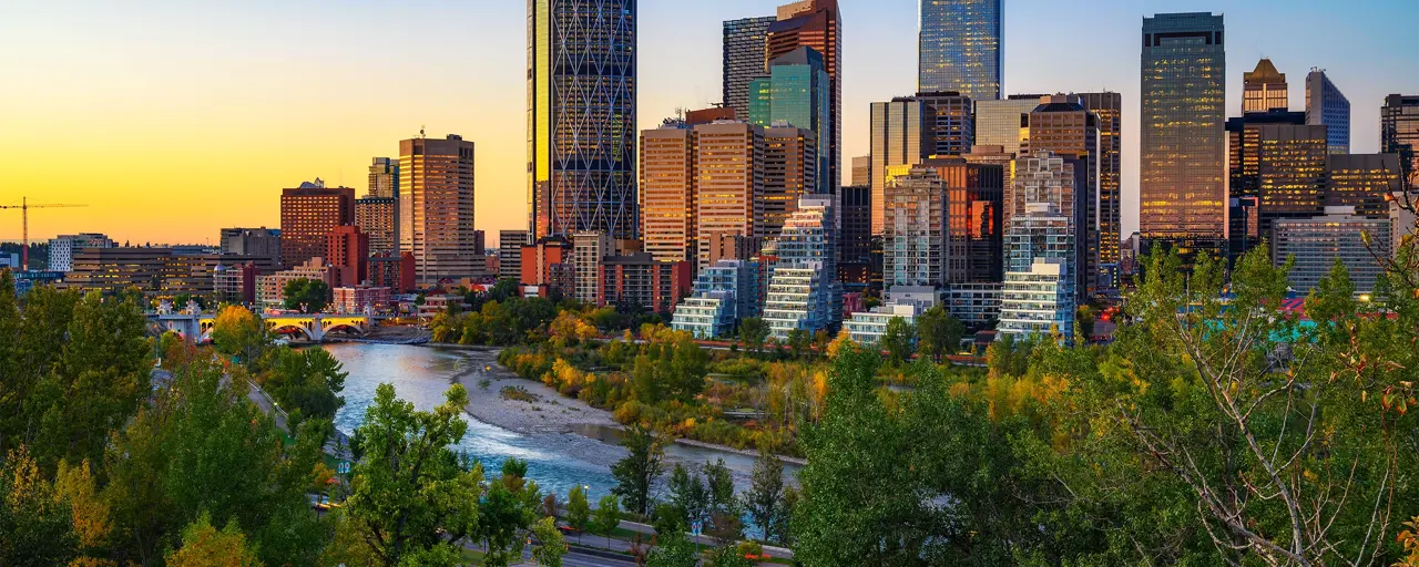 Canada skyline with buildings in the background and a river in the foreground, at sunset