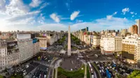 Skyline view of Buenos Aires with lots of cars on the road and tall monument in the middle 