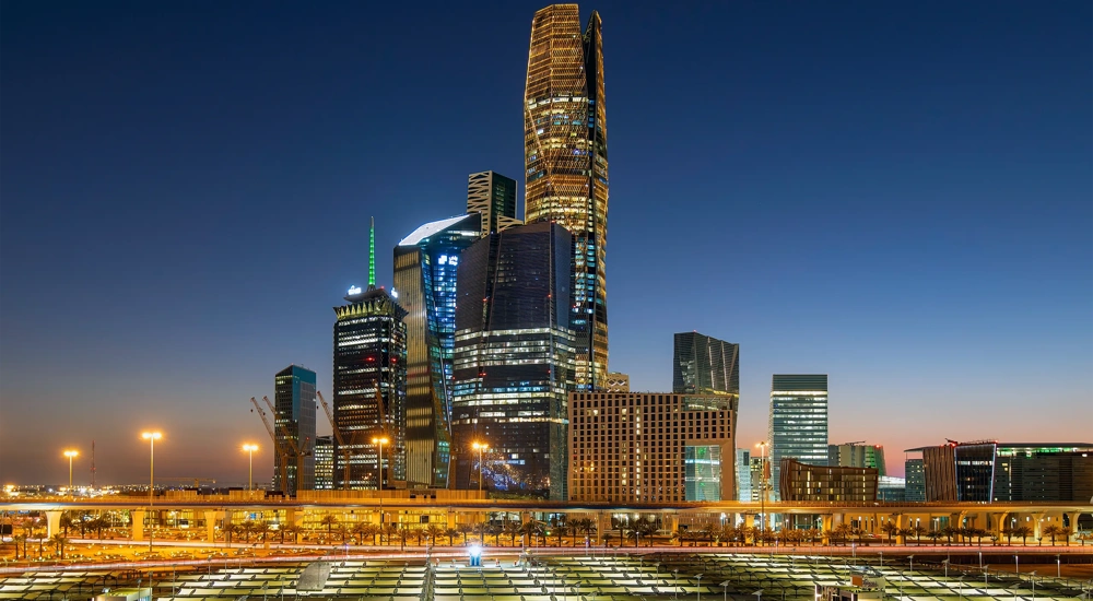 Aerial view of Riyadh at night with illuminated modern skyscrapers and busy streets under a clear dark sky, Al Olaya street