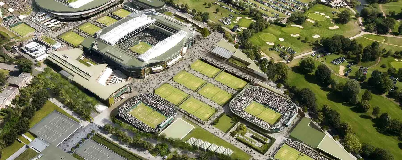 An aerial shot of Wimbledon tennis courts, including Centre Court and surrounding green areas. 