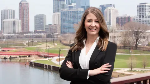 Portrait of Whitney Knuf Ahn, Vice President, Nashville Cost Centre Leader, outside in front of tall city buildings